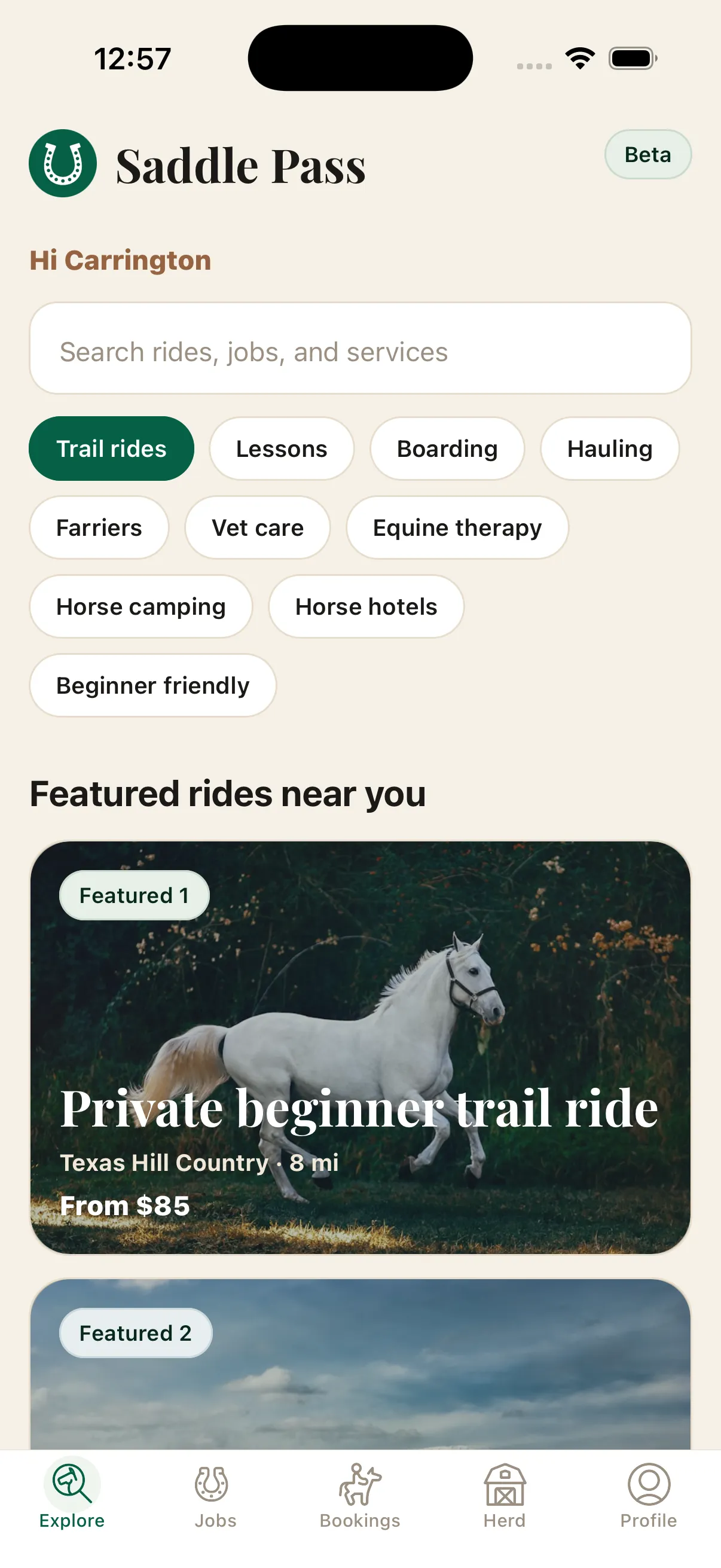 Saddle Pass home screen with a cream background, a header bar showing a horseshoe logo, the words Saddle Pass, and a Beta pill, then a greeting, search field, category chips, and featured ride cards.